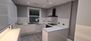 A kitchen with white cabinets and a window