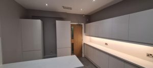 A kitchen with white cabinets and a door