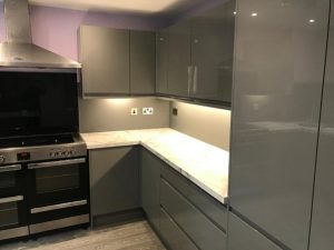 A kitchen with grey cabinets and a stove