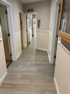 A hallway with white walls and wood floors
